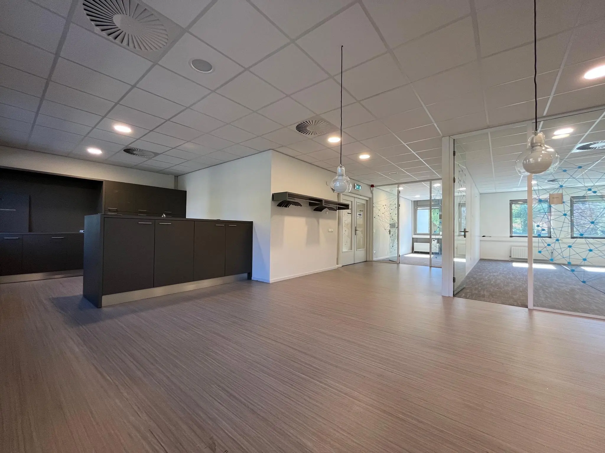 Moderne, lichte kantoorruimte aan de Barchman Wuytierslaan met glazen wanden en ingebouwde kasten.